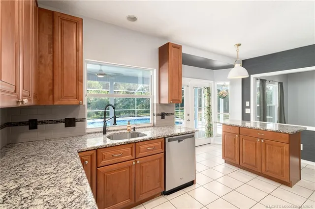 a large kitchen with kitchen island granite countertop a sink and dishwasher wooden cabinets with a granite countertops