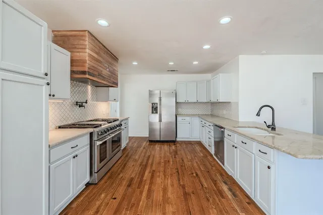 a large kitchen with a stove top oven sink and cabinets