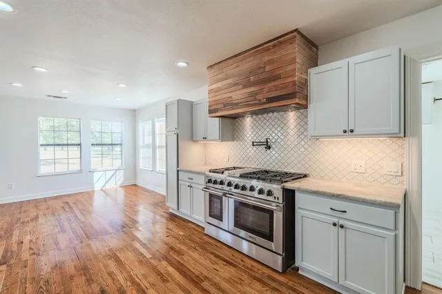 a kitchen with wooden floors and appliances