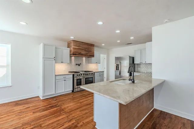 a kitchen with stainless steel appliances granite countertop a sink stove and refrigerator