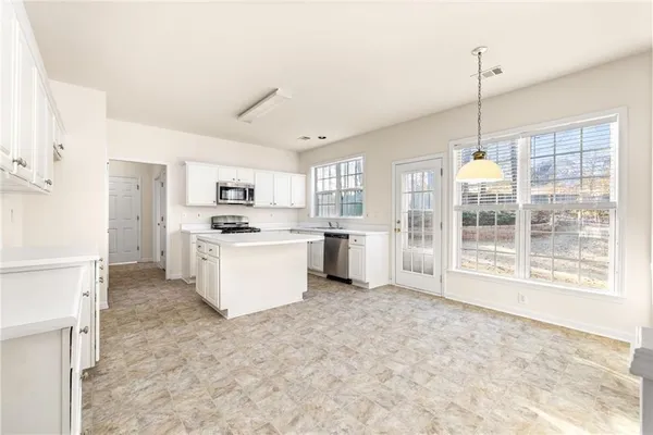 a kitchen with stainless steel appliances cabinets and a window