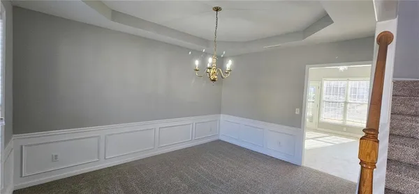 a view of an empty room with chandelier