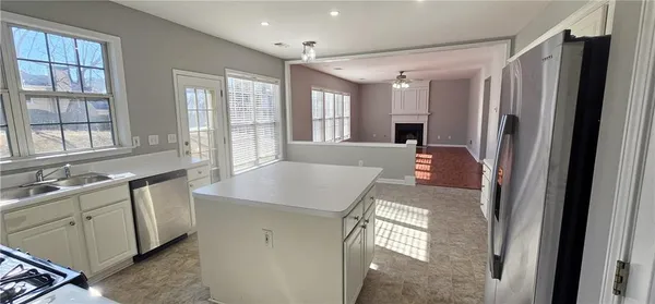 a kitchen with kitchen island a sink stove and refrigerator