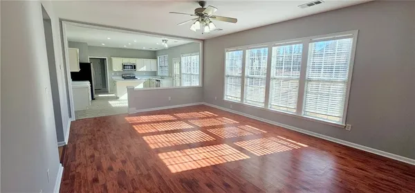 a view of a room with wooden floor and a kitchen space
