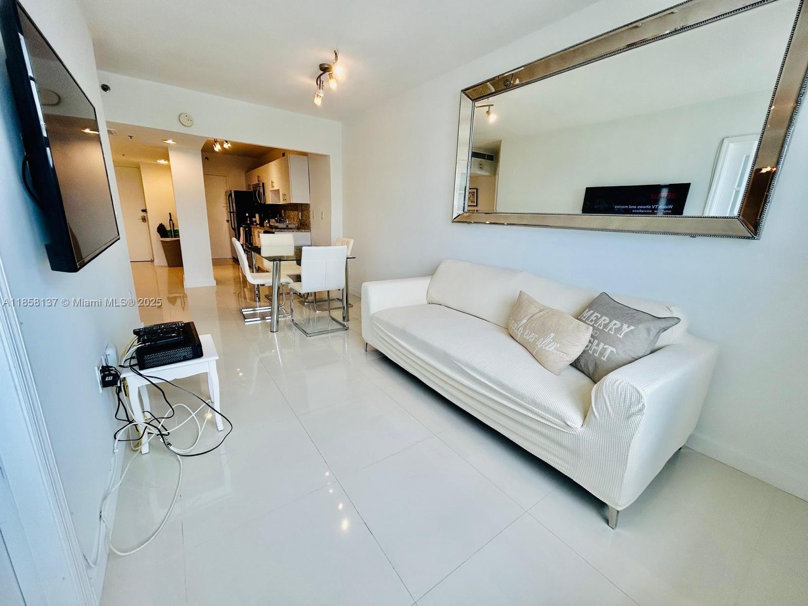 100 Lincoln Road, Unit 1406 Miami Beach, FL 33139 - Photo 1 of 14 a living room with furniture and a flat screen tv