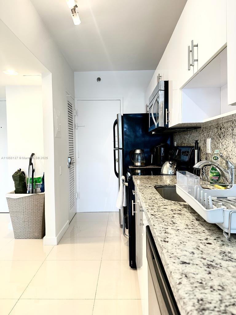 100 Lincoln Road, Unit 1406 Miami Beach, FL 33139 - Photo 6 of 14 a kitchen with a stove and a sink