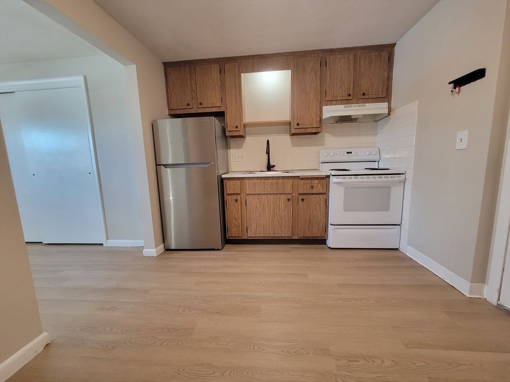 83 Pleasant Street, Unit 24 Marlborough, MA 01752 - Photo 1 of 6 a kitchen with a refrigerator sink and cabinets