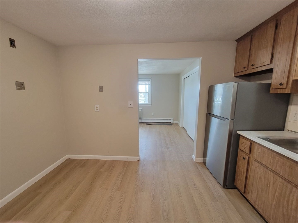 83 Pleasant Street, Unit 24 Marlborough, MA 01752 - Photo 2 of 6 a view of a kitchen with wooden floor and electronic appliances