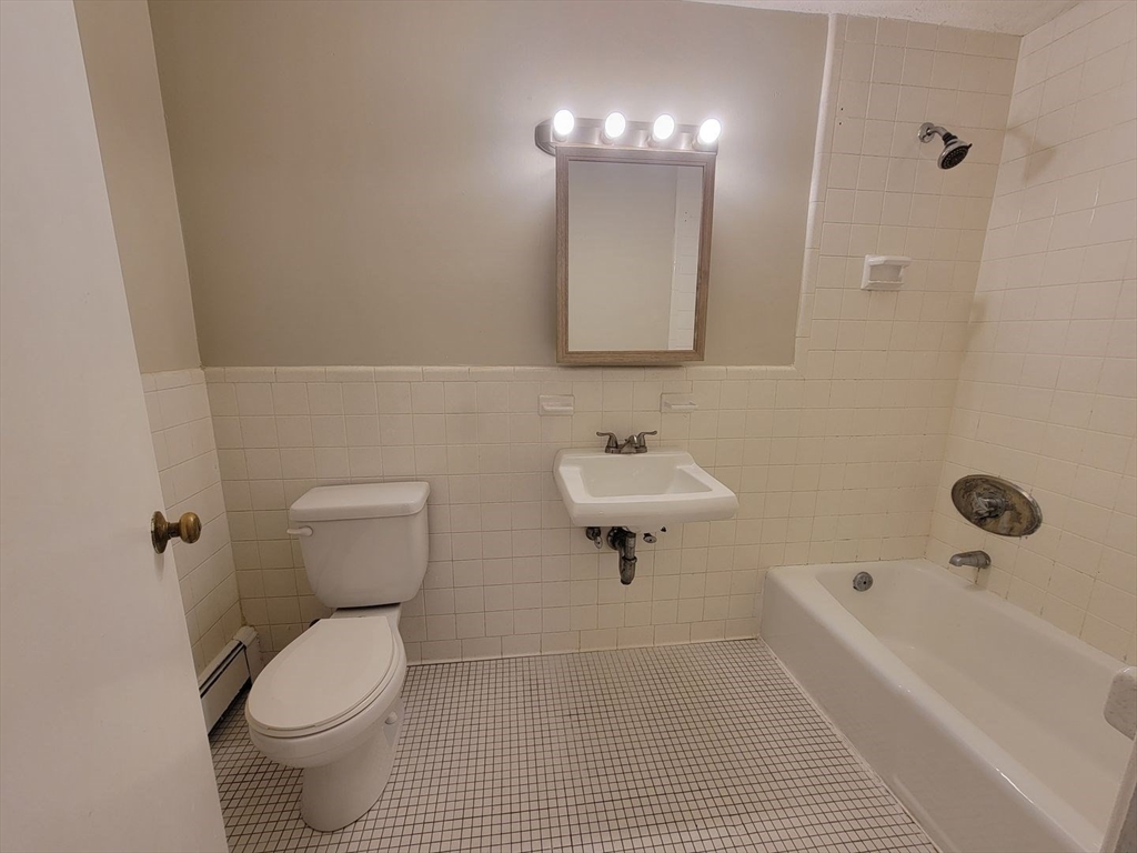 83 Pleasant Street, Unit 24 Marlborough, MA 01752 - Photo 6 of 6 a bathroom with a toilet a sink a mirror and bathtub