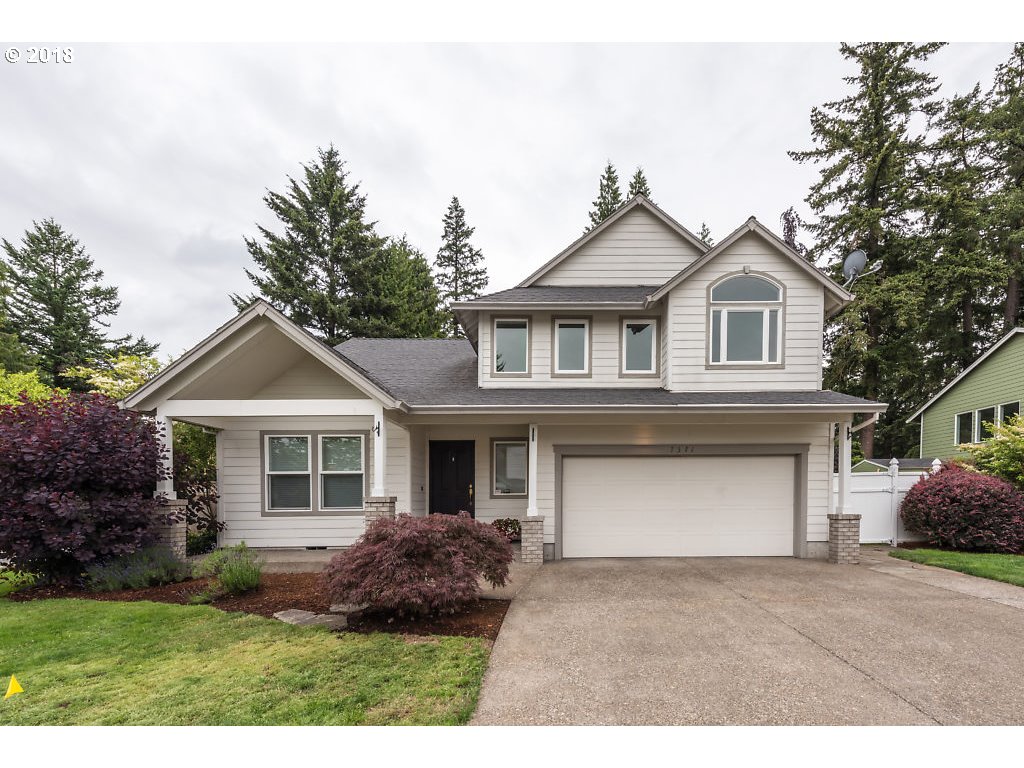 7571 Southwest Mapleleaf Street Portland, OR 97223 - Photo 1 of 32 a front view of a house with a garden and trees