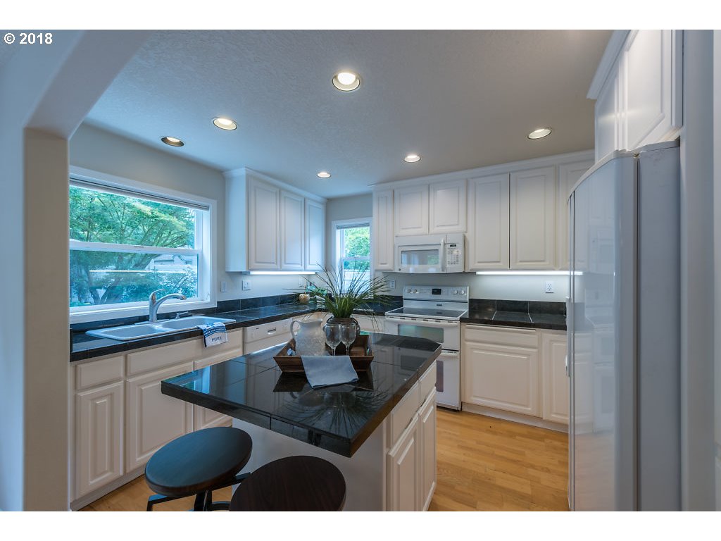 7571 Southwest Mapleleaf Street Portland, OR 97223 - Photo 13 of 32 a kitchen that has a sink cabinets counter space and appliances