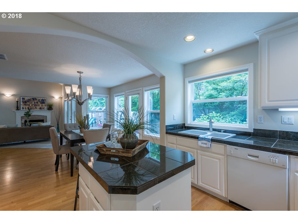 7571 Southwest Mapleleaf Street Portland, OR 97223 - Photo 15 of 32 a kitchen with granite countertop a sink and cabinets