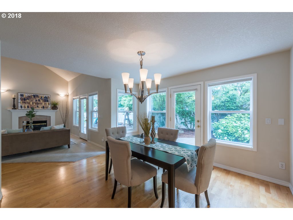 7571 Southwest Mapleleaf Street Portland, OR 97223 - Photo 10 of 32 a dining room with furniture a chandelier and wooden floor