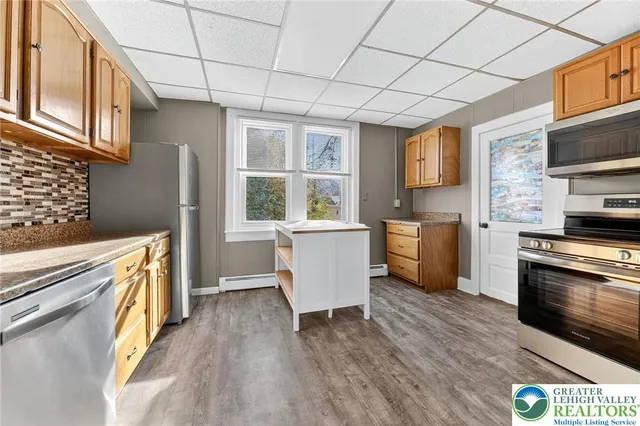 a kitchen with stainless steel appliances granite countertop a stove a sink and a refrigerator