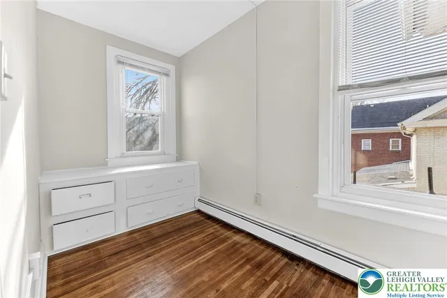 a view of empty room with window and cabinet