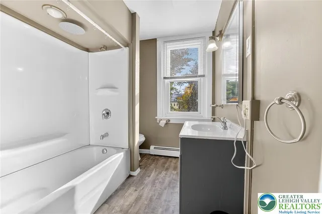 a bathroom with a tub sink and mirror