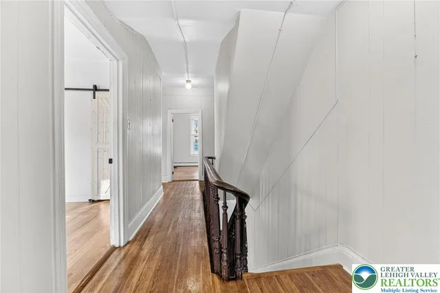 a view of a hallway with wooden floor