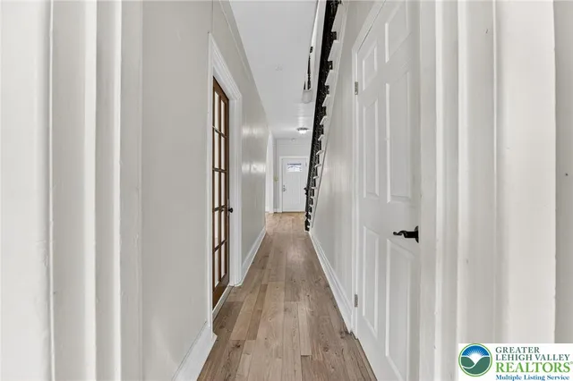 a view of a hallway with wooden floor and staircase
