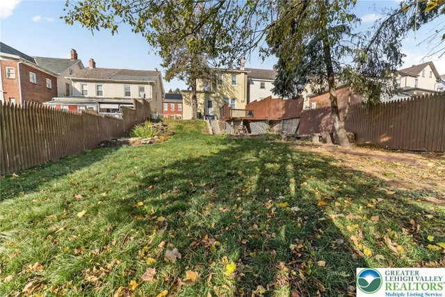 a view of a yard with plants and trees