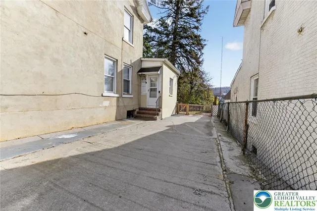 a view of a street with a car parked beside a road