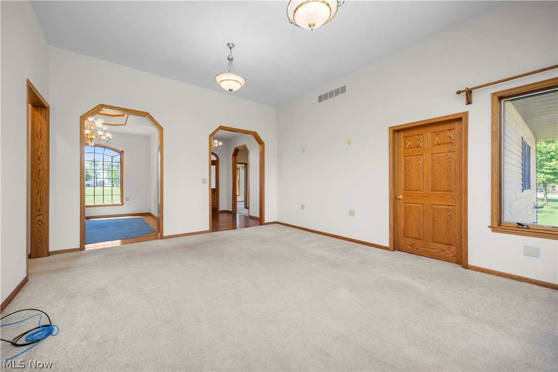 51488 Peck Wadsworth Road Wellington, OH 44090 - Photo 21 of 50 Spacious living area featuring light-toned carpeting, white walls, and wood-trim baseboards
