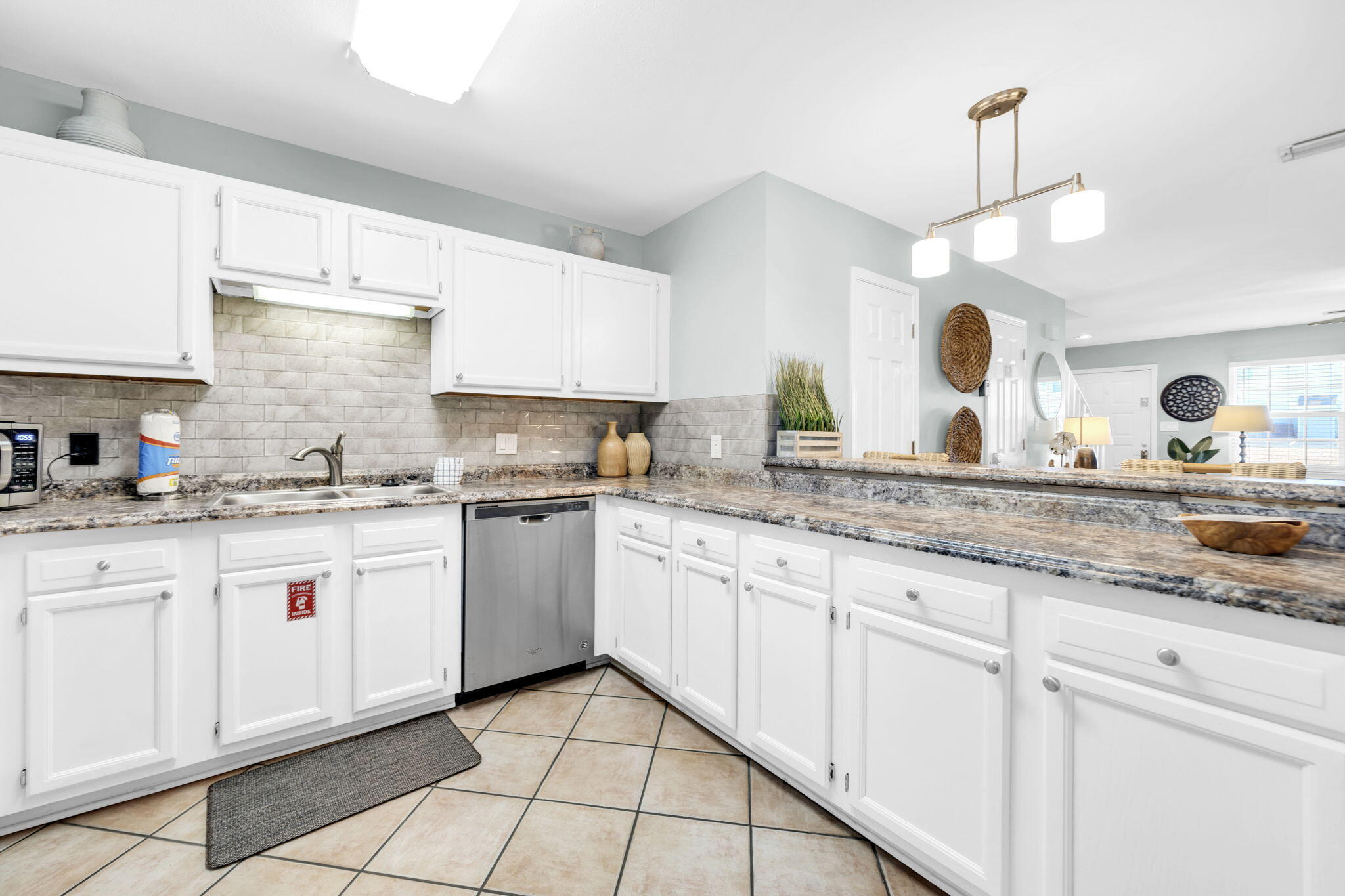 241 Ellis Road, Unit 43 Miramar Beach, FL 32550 - Photo 12 of 49 a kitchen with granite countertop white cabinets and white appliances