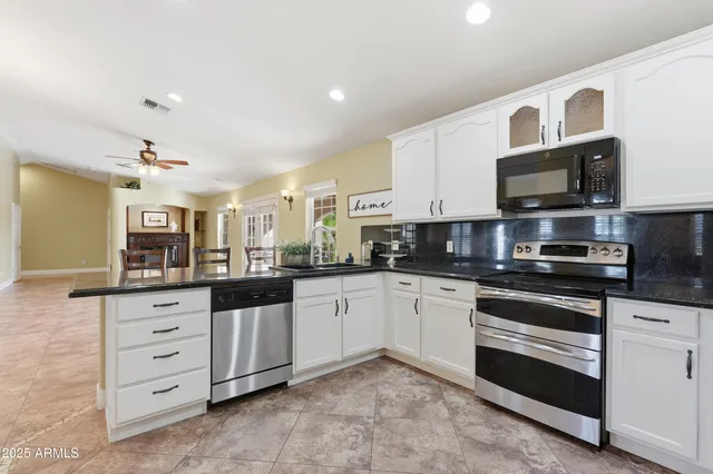 a kitchen with stainless steel appliances granite countertop a refrigerator stove and sink