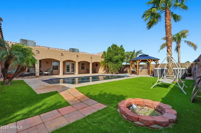 a view of a house with brick walls plants and large tree