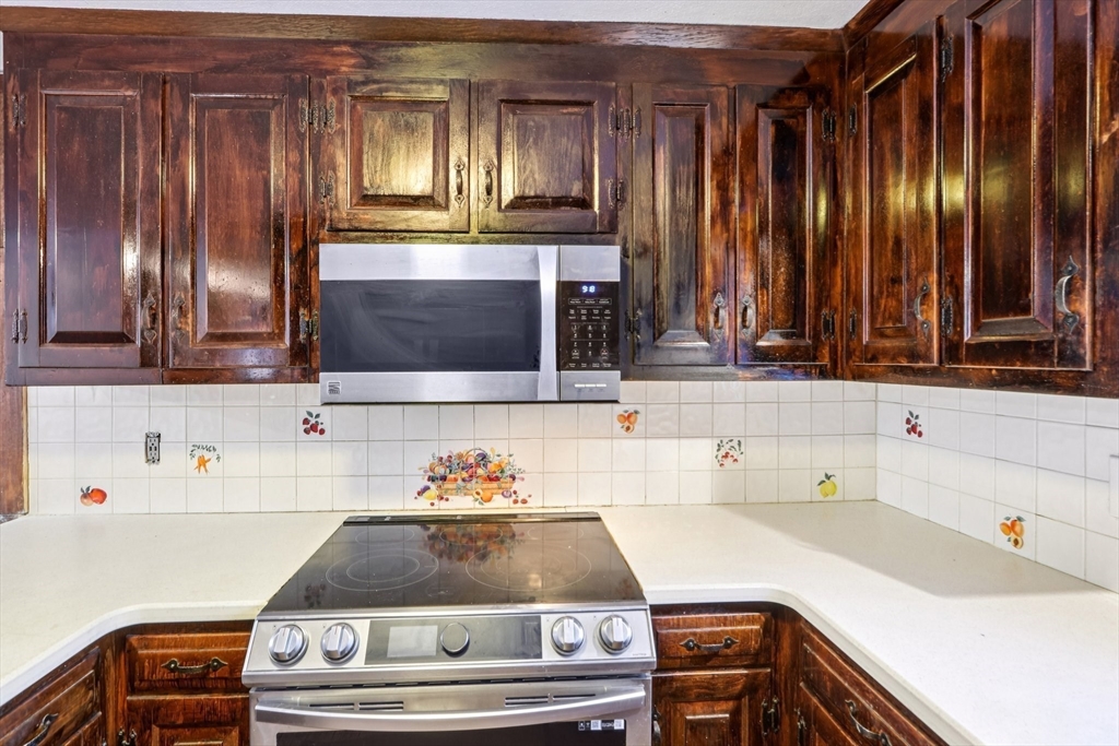 143 Hudson Road Stow, MA 01775 - Photo 24 of 42 a kitchen with kitchen island a sink and a stove with wooden floor