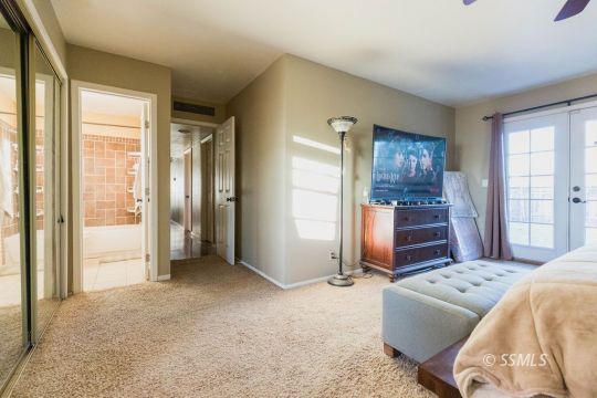 925 West St George Avenue Ridgecrest, CA 93555 - Photo 15 of 24 a bedroom with a bed and a chandelier