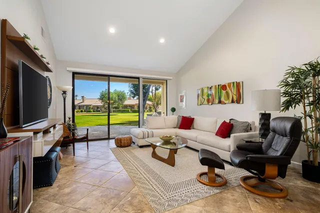 a living room with furniture flat screen tv and a large window