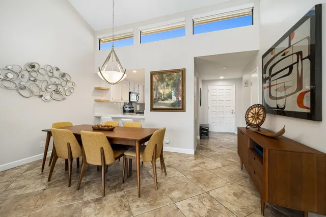 a view of a dining room and livingroom with furniture a rug a fireplace and a painting