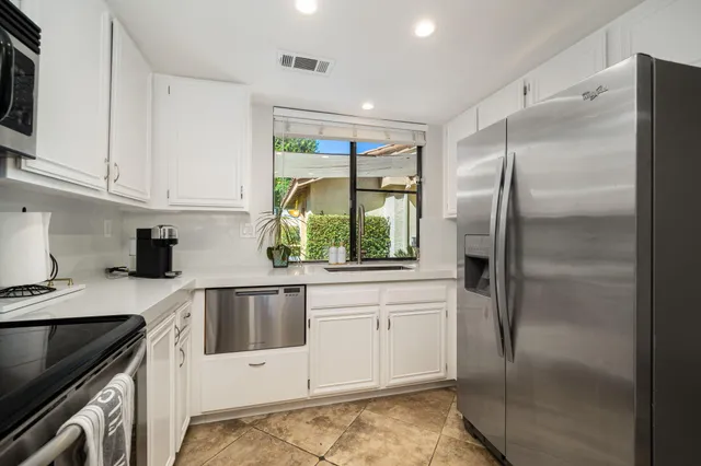 a kitchen with a refrigerator a sink and cabinets