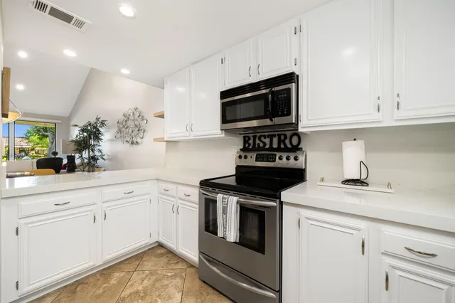 a kitchen with white cabinets stainless steel appliances and sink