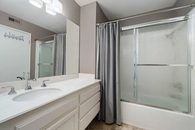 a bathroom with a granite countertop sink mirror and shower