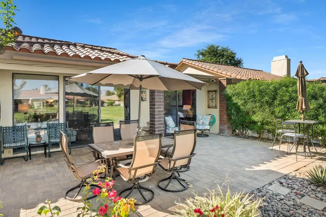 a view of a patio with table and chairs potted plants