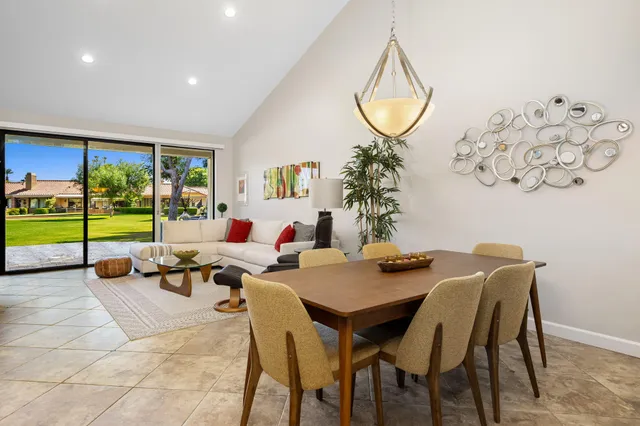 a living room with furniture a table and a potted plant
