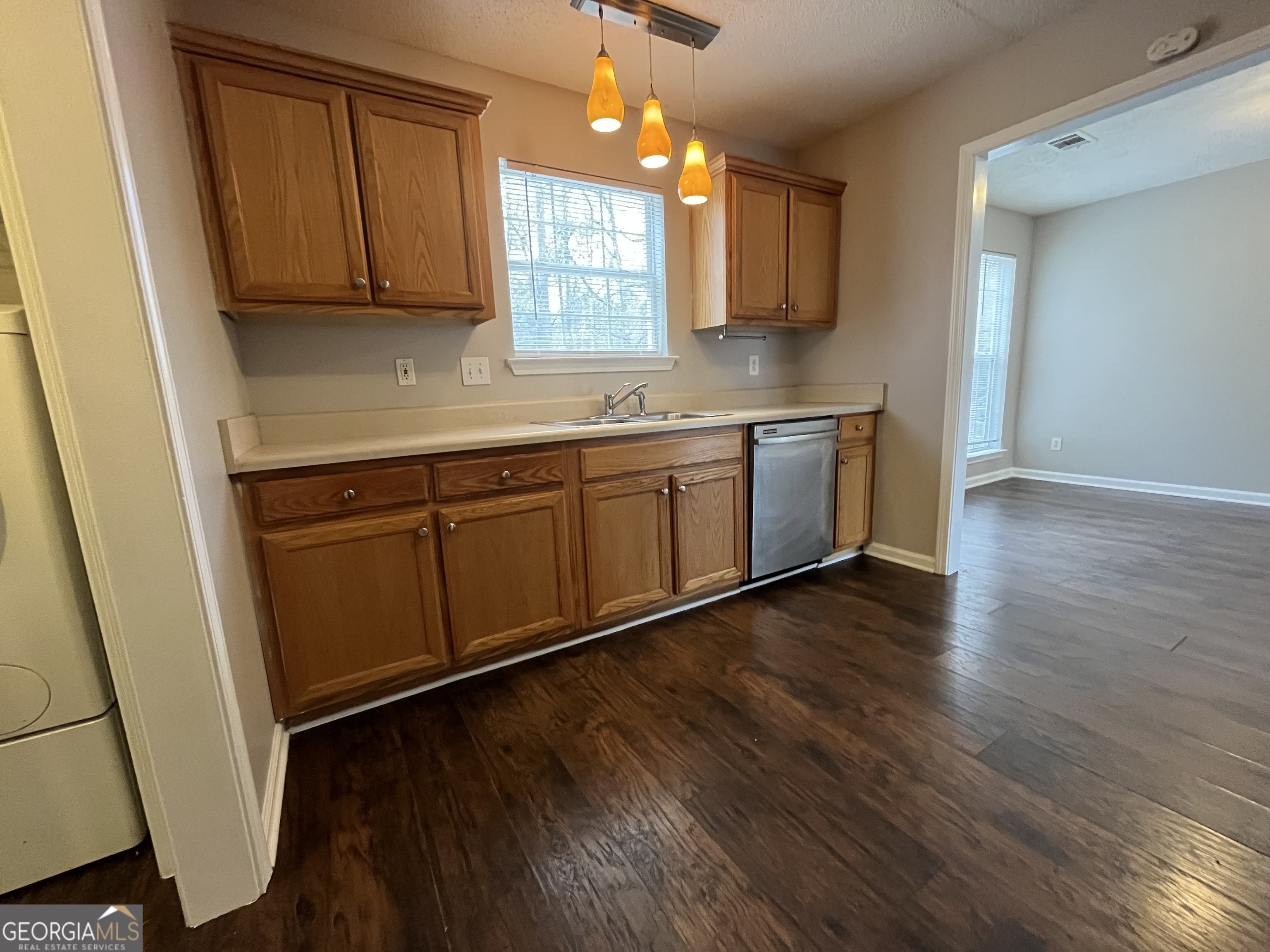156 Galway Lane Hampton, GA 30228 - Photo 16 of 44 a kitchen with granite countertop wooden floors wooden cabinets a sink and a window