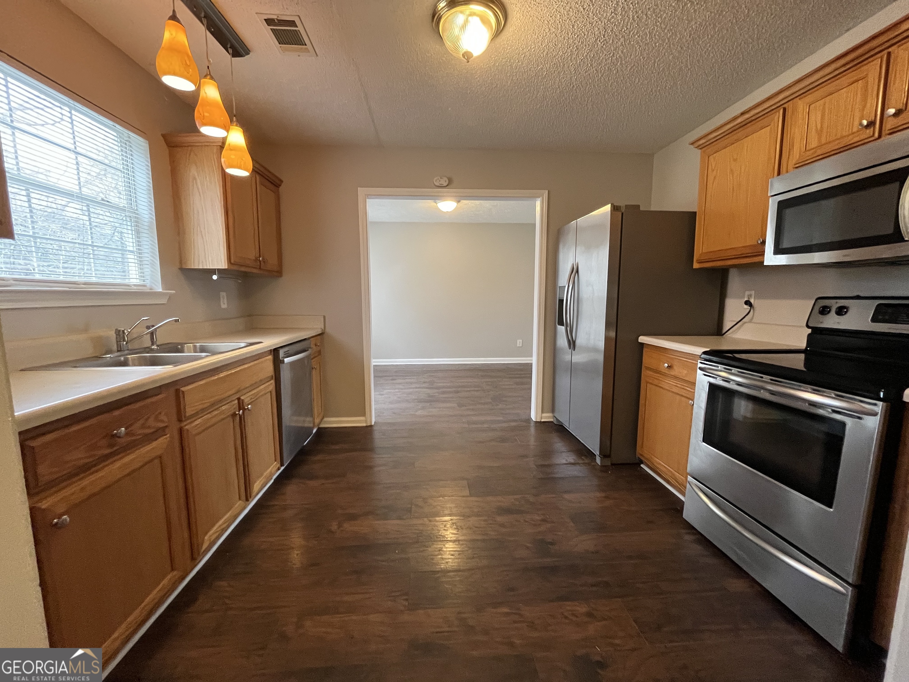 156 Galway Lane Hampton, GA 30228 - Photo 17 of 44 a kitchen with stainless steel appliances a stove a sink and a refrigerator