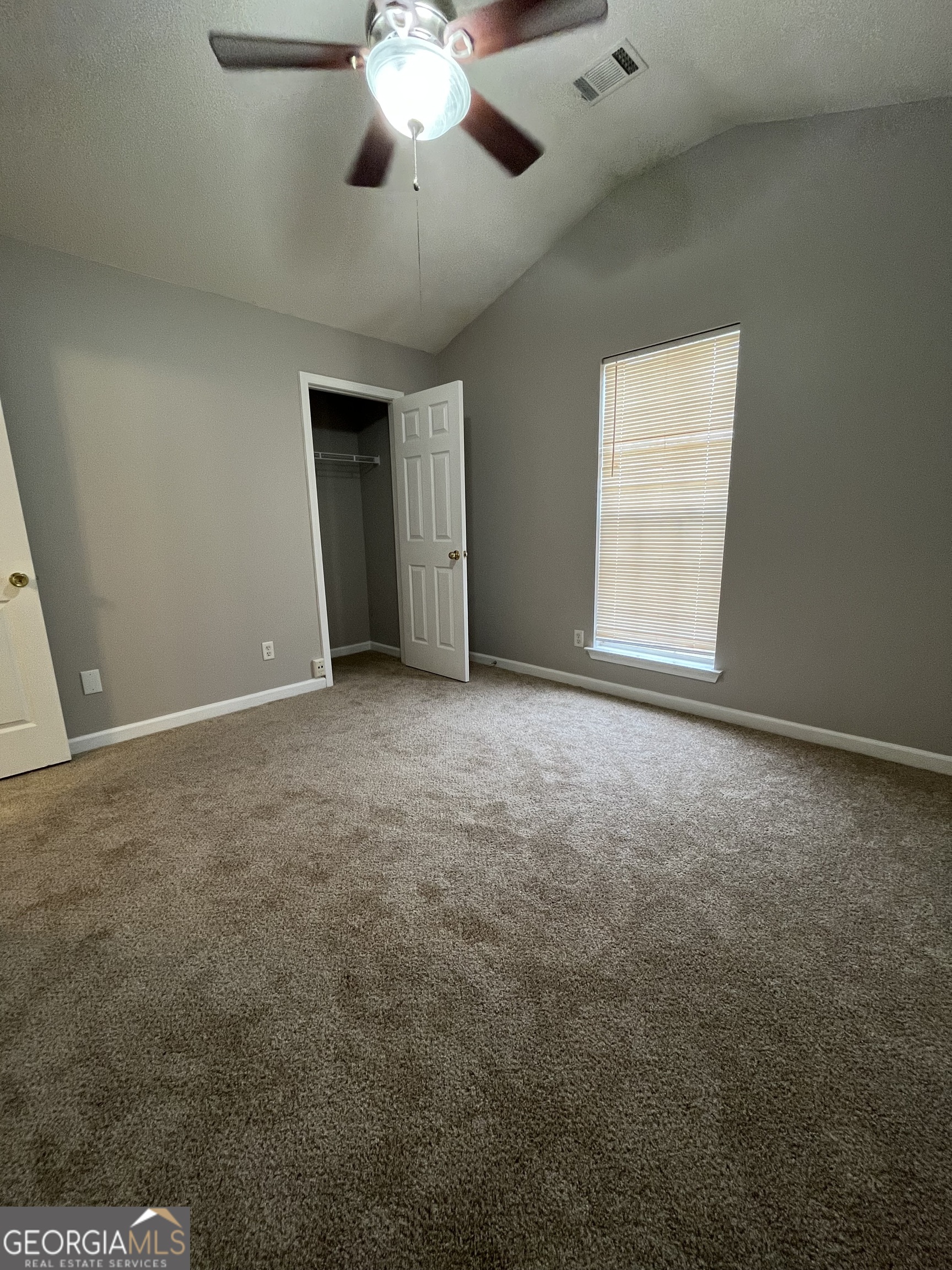 156 Galway Lane Hampton, GA 30228 - Photo 26 of 44 an empty room with a chandelier fan and windows