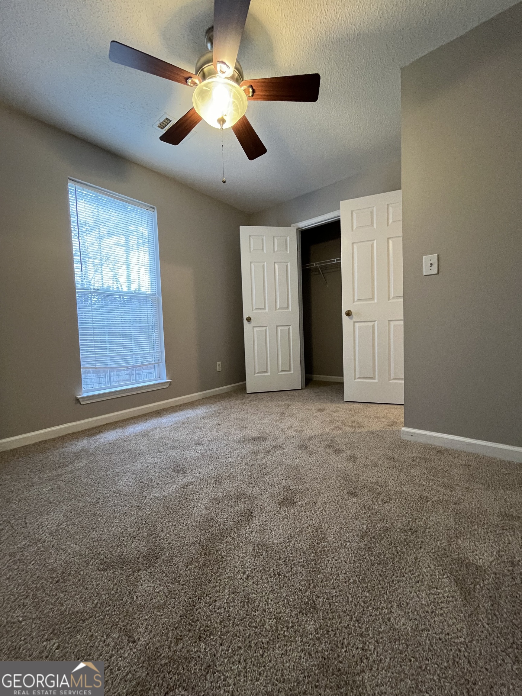 156 Galway Lane Hampton, GA 30228 - Photo 32 of 44 an empty room with windows and fan