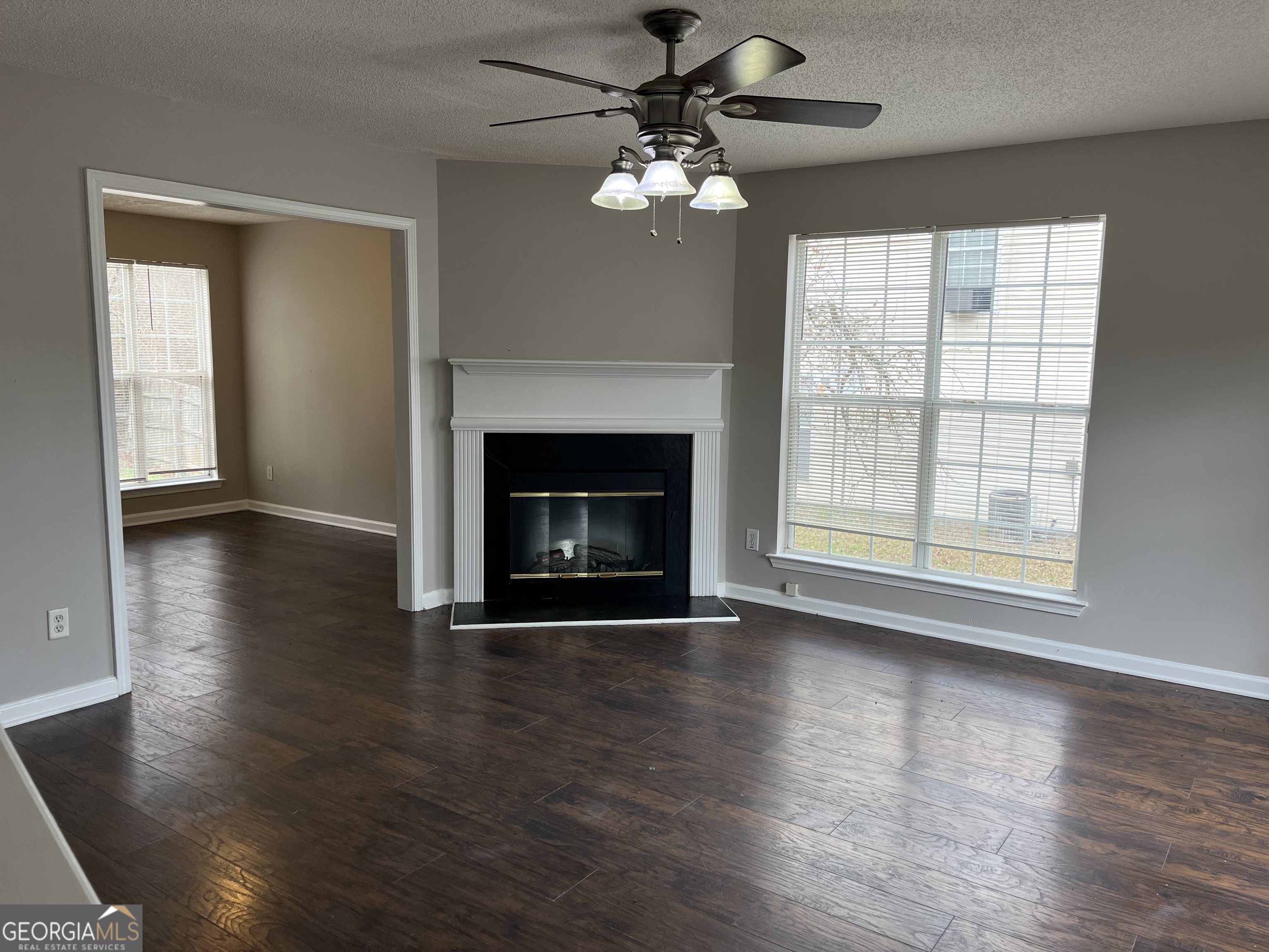 156 Galway Lane Hampton, GA 30228 - Photo 8 of 44 an empty room with wooden floor fireplace and windows