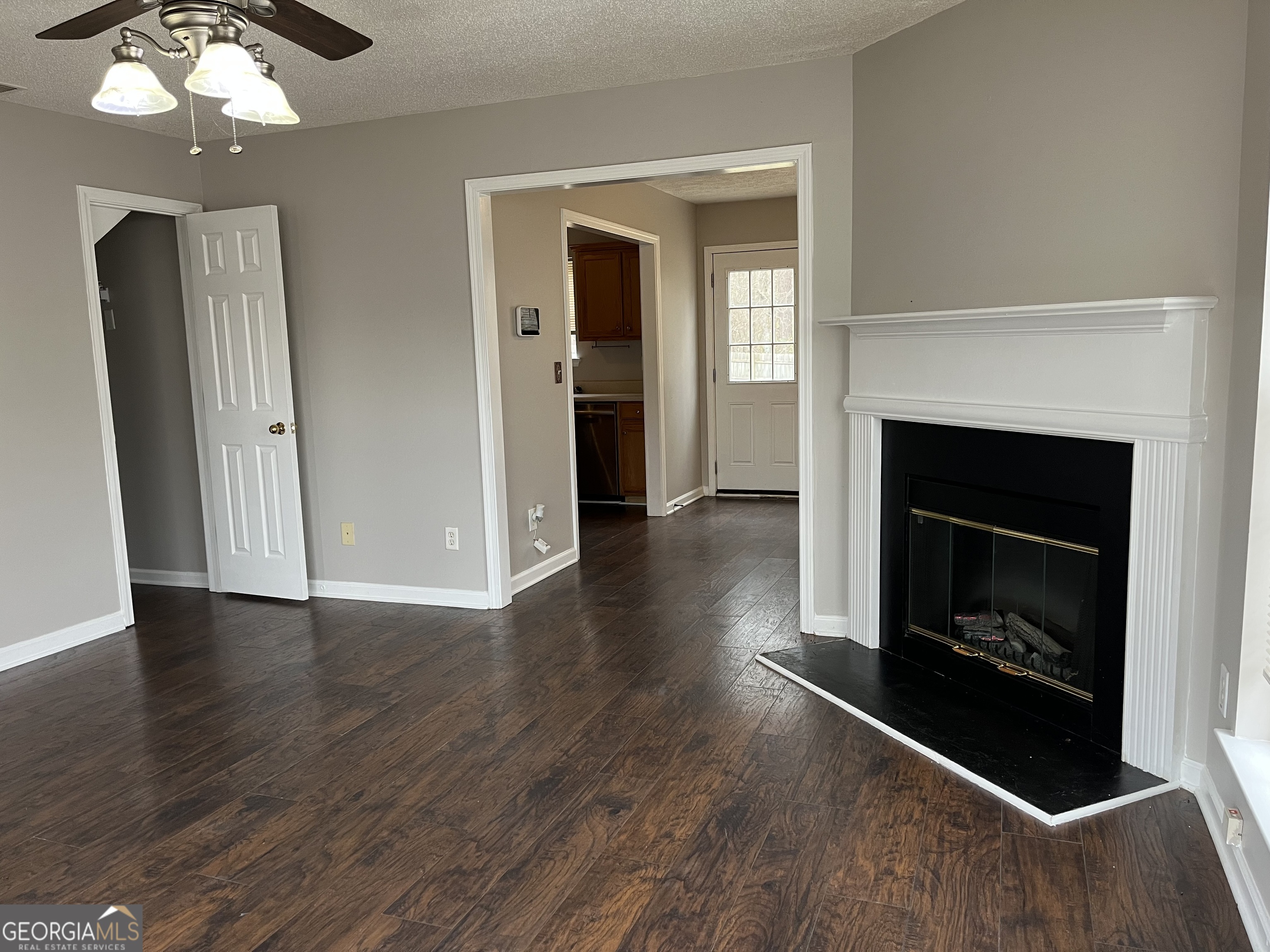 156 Galway Lane Hampton, GA 30228 - Photo 10 of 44 an empty room with wooden floor fireplace and windows