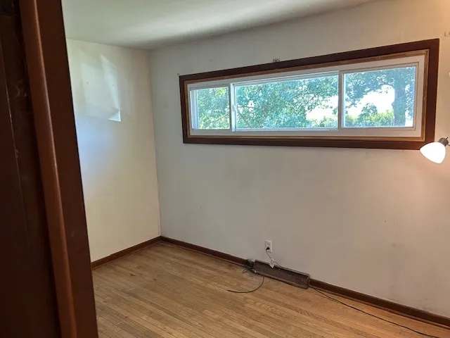 a view of a small space with wooden floor and a window