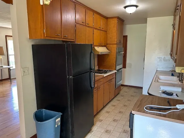 a kitchen with stainless steel appliances granite countertop a refrigerator and a sink