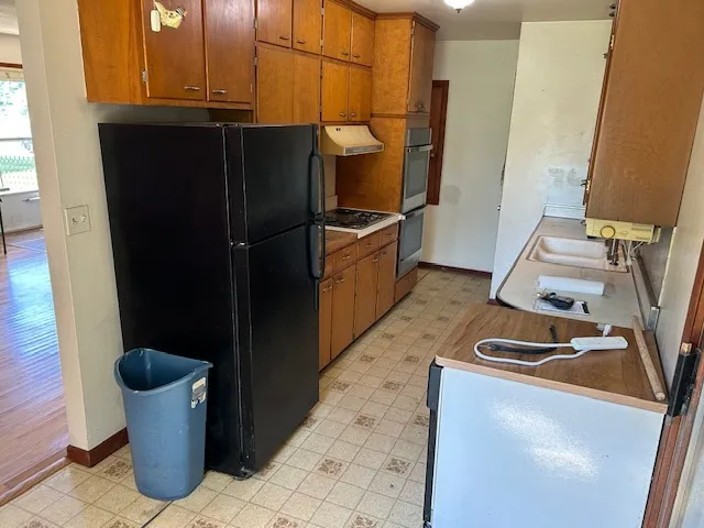 a kitchen with a refrigerator and a stove
