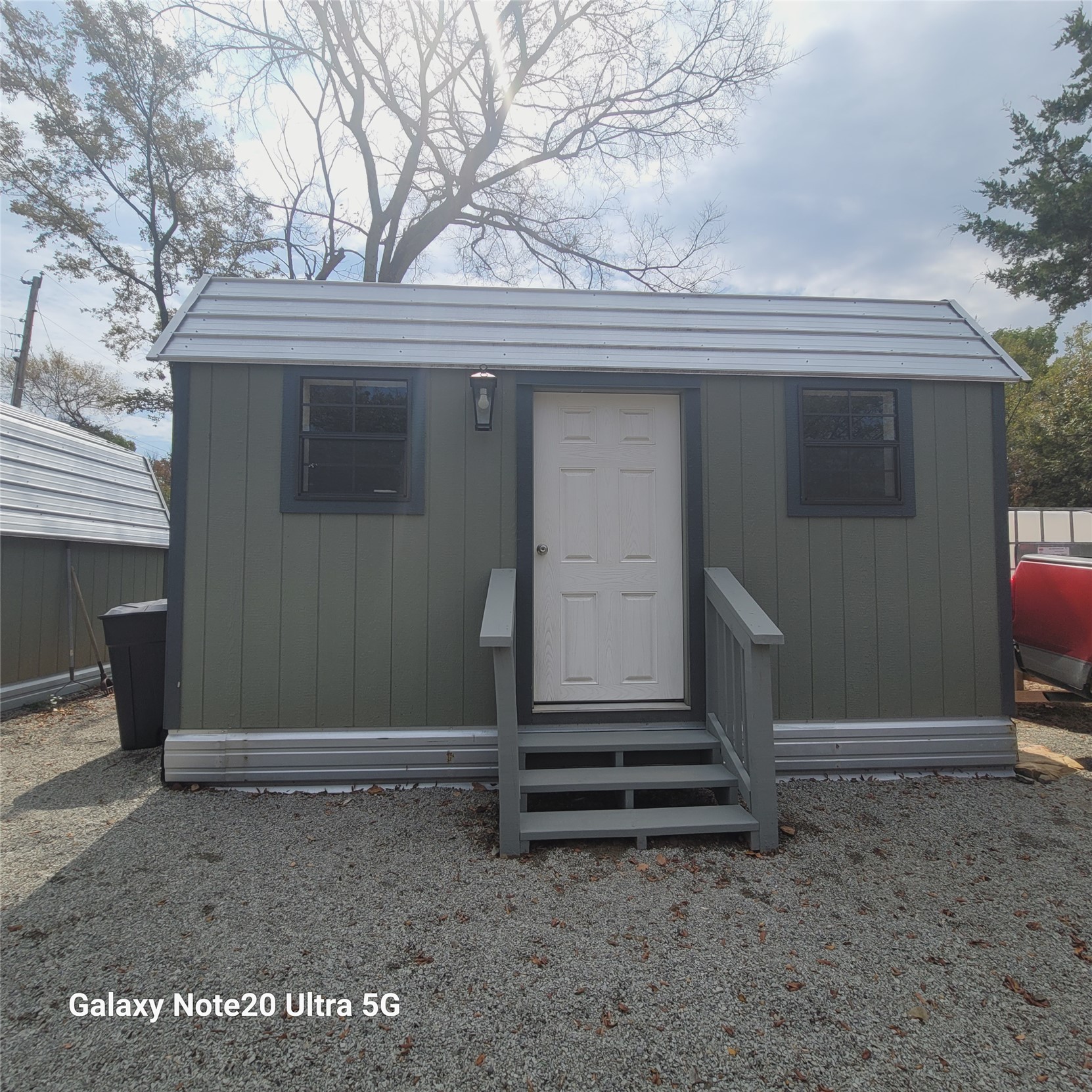 115 Locust Road Stigler, OK 74462 - Photo 7 of 29 Vertical siding exterior with a light gray metal roof