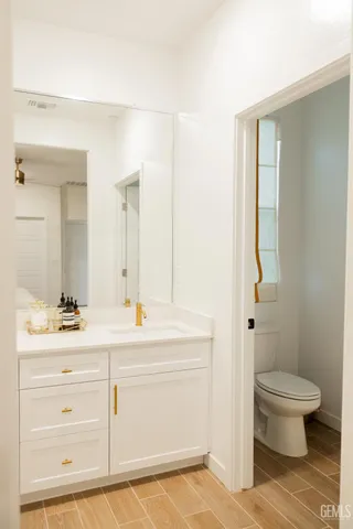 a bathroom with a sink a toilet a mirror and vanity