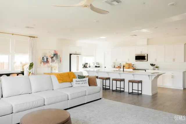 a living room with furniture white walls and a flat screen tv