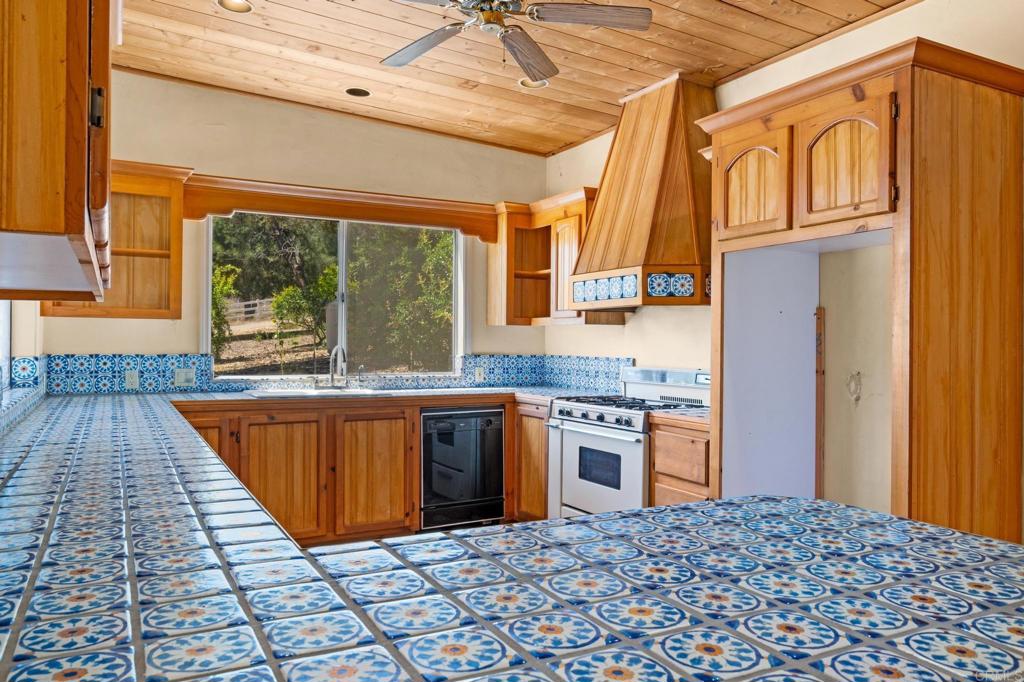 13511 Hilldale Road Valley Center, CA 92082 - Photo 38 of 46 a kitchen with stainless steel appliances granite countertop a stove a sink and a microwave